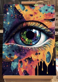 an eye with colorful paint splattered all over it, sitting on a table