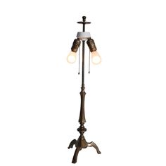 an old fashioned floor lamp with two lamps on it