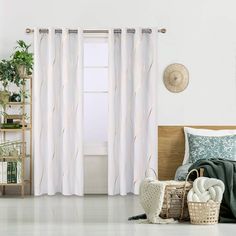 a bed room with a neatly made bed and white curtains