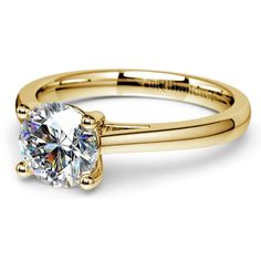 a yellow gold engagement ring with a round diamond