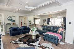 a living room filled with furniture and a cowhide rug