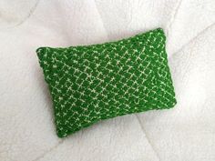 a green pillow sitting on top of a white blanket