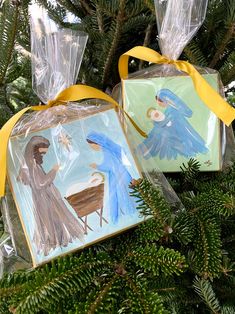 two christmas ornament hanging from a tree with yellow ribbon and decorations on it