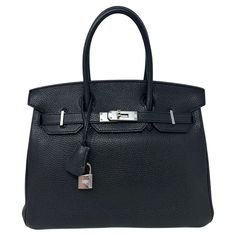 Hermes Black Birkin 30 Bag. Silver palladium hardware. Togo leather. Interior clean. Looks like brand new. Plastic is still on the hardware. Classic black Birkin is an investment. Includes clochette, lock, keys, and dust bag. Guaranteed authentic. Epsom Leather Bags With Lock For Everyday Use, Classic Business Shoulder Bag With Lock, Evening Bags With Lock In Epsom Leather, Evening Epsom Leather Bag With Lock, Top Handle Epsom Leather Bag With Lock, Top Handle Bags In Epsom Leather With Lock, Epsom Leather Top Handle Bags With Lock, Timeless Travel Bags With Lock, Modern Travel Bag With Lock