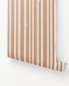 a striped wallpaper with white and brown stripes on the outside, in an off - white background