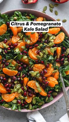 a bowl filled with oranges, pomegranate and kale salad