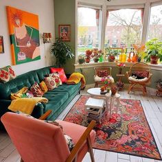 a living room filled with lots of furniture and colorful pillows on top of it's couches