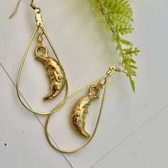 Handmade gold-tone half moon earrings with ear wire closure. I found these vintage charms and wanted to make them into a more dynamic earring! Moons measure 1" long and total drop of earring is 2.25". Perfect with any outfit! Gold Crescent Earrings With Moon Phase Detail, Gold Crescent Hoop Earrings With Ear Wire, Vintage Crescent Moon Charm Earrings, Brass Teardrop Earrings With Moon Charm, Teardrop Brass Earrings With Moon Charm, Gold Moon Shaped Metal Hoop Earrings, Gold Crescent Brass Earrings, Gold Moon-shaped Metal Hoop Earrings, Gold Crescent Hoop Earrings With Moon Phase