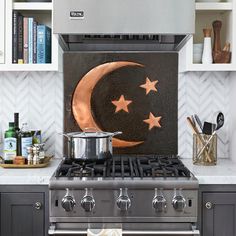 a stove top oven sitting under a painting on the wall