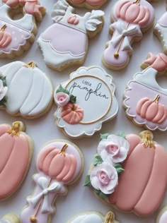 many decorated cookies are displayed on a white tablecloth with the words little pumpkin written in it