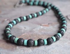 "A beaded mens necklace made with lava rock and turquoise magnesite. The necklace measures 20\". More lengths are listed. The mannequin's neck size is 14.5\". A matching bracelet is also available. Please let us know if you would like to add one to the order. The clasp is gunmetal toggle but a gunmetal lobster claw, stainless steel lobster and lead free pewter toggle are also available. Stainless steel will not tarnish or oxidize and is hypoallergenic. All DLD jewelry comes in a brown kraft pape Black Statement Earrings, Mens Beaded Necklaces, Obsidian Necklace, Rock Necklace, Boys Jewelry, Surfer Necklace, Turquoise Bead Necklaces, Lava Rock, Bridesmaid Accessories