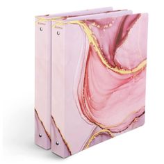 two binders with pink and gold designs on them