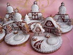 several decorated gingerbread houses on a pink background