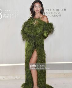 a woman in a green dress poses on the red carpet at an award ceremony for her role