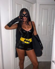 a woman dressed as batman posing for the camera