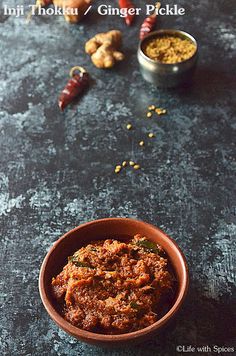 a bowl filled with food sitting on top of a table next to other bowls and spices