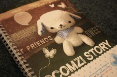 a white stuffed animal sitting on top of a book with the title'my friend's comiz story '