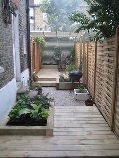 an outdoor garden with wooden steps leading up to the back door and seating area on either side