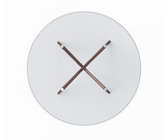 a white plate with two crossed wooden sticks on the front and back of it, against a white background