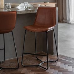 two brown barstools sitting on top of a wooden floor