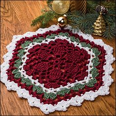 a crocheted christmas ornament is on the floor next to a pine tree