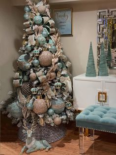 a decorated christmas tree in a living room with blue and silver ornaments on the top