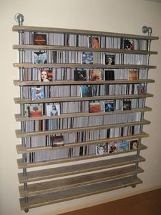 a wall mounted book shelf filled with lots of books on top of a hard wood floor