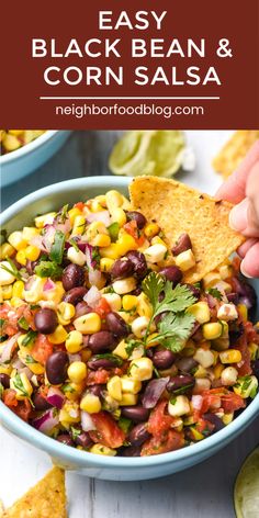 a bowl filled with black bean and corn salsa next to tortilla chips on the side