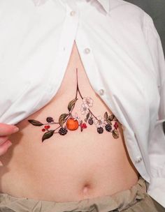 a woman's stomach with fruit and leaves on it