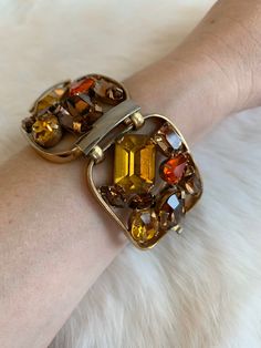 "Vintage 1940's statement signed Napier bracelet. Gold tone bracelet with amber, brown, and bright orange rhinestone crystals. Rhinestones are oval, circle, baguette, emerald, and tear drop cut. Bracelet in excellent condition with minor wear due to age. High quality and high shine rhinestones. Measurements Length: 6-3/4\" / Width: 1-1/2\" / Unless otherwise stated all vintage items are used and may have minor to moderate wear or discoloration considering the age of the item. Most items have bee Vintage Jeweled Jewelry For Evening, Adjustable Vintage Amber Jewelry, Vintage Orange Metal Jewelry, Retro Jeweled Gold Jewelry, Vintage Oval Multi-stone Bracelets, Retro Gold Jeweled Jewelry, Multi-stone Metal Jewelry For Party, Retro Orange Jewelry For Formal Occasions, Retro Metal Jewelry