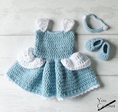 a crocheted baby dress and booties are on the floor next to a hat