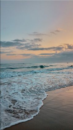 the ocean waves come in to shore at sunset