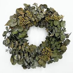 a wreath made out of green leaves and yellow berries on a white background with copy space