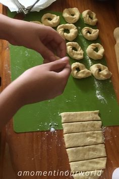 someone is making dough on a green cutting board