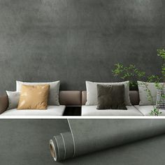 a couch with several pillows on it next to a plant