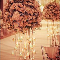 flowers and candles are arranged in tall vases