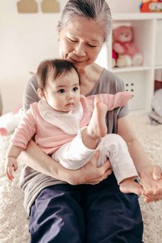 an older woman holding a baby in her lap