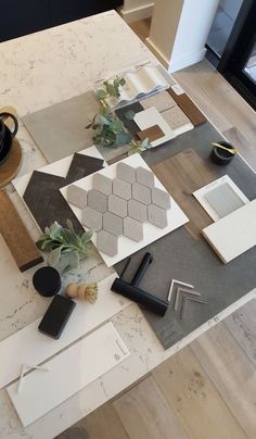 the table is covered with different types of tiles and plants on it, including flowers