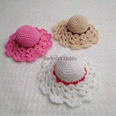 three crocheted hats sitting on top of a white blanket