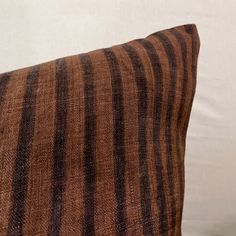 a brown and black striped pillow sitting on top of a bed