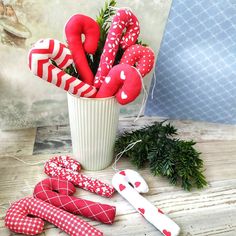 a vase filled with red and white candy canes on top of a wooden table