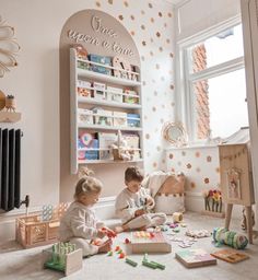 two children playing with toys in a room