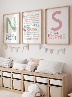 three framed pictures hang on the wall above a wooden bench with storage bins underneath