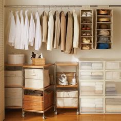 an organized closet with clothes and linens hanging on the wall, drawers stacked in front of each other