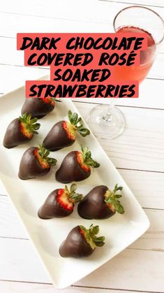 chocolate covered strawberries are arranged on a plate next to a glass of rose wine