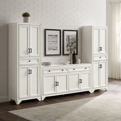 a white cabinet with drawers and pictures on the wall above it in a living room