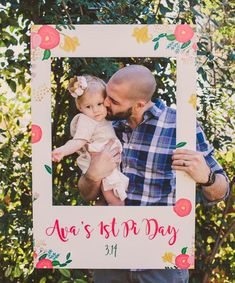 a man holding a baby in front of a photo frame with the words, happy father's day on it