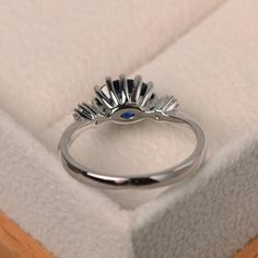 a white gold ring with an evil eye in it's center sits inside a box