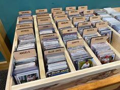 a wooden table topped with lots of different types of cd's and cds in bins