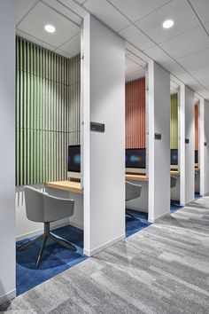 an office with multiple computers and desks in it's cubicle area,